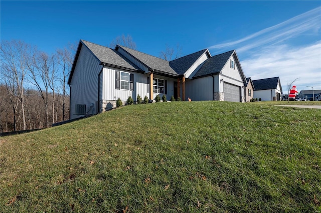 view of front facade featuring a front lawn, central AC unit, and a garage