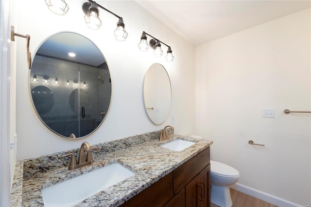 bathroom featuring hardwood / wood-style floors, toilet, an enclosed shower, and vanity