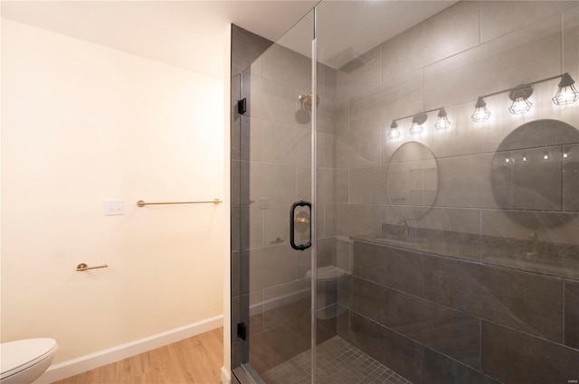 bathroom featuring hardwood / wood-style floors, toilet, and walk in shower