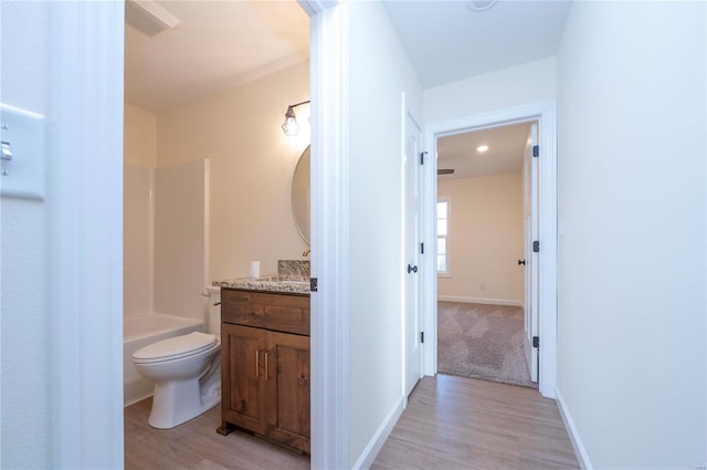 full bathroom featuring hardwood / wood-style flooring, vanity, toilet, and bathing tub / shower combination