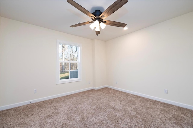 carpeted spare room featuring ceiling fan