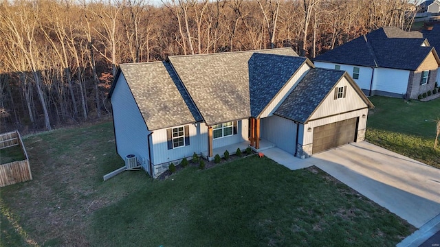 view of front of house featuring a front yard, central AC, and a garage