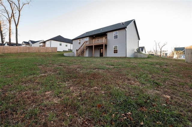 back of property featuring a yard and a wooden deck