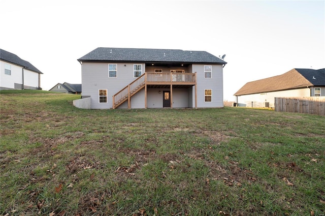 back of house featuring a wooden deck and a lawn