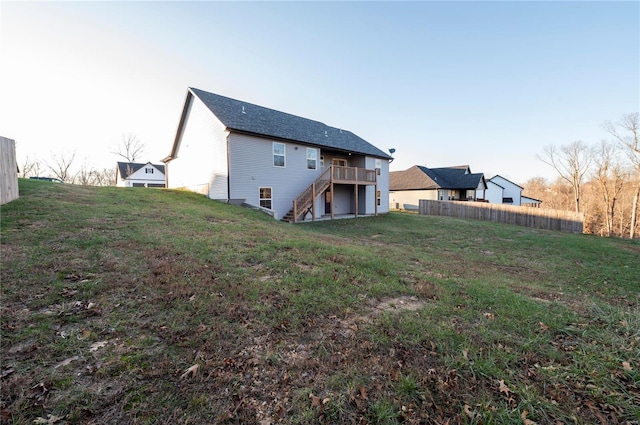 rear view of property with a wooden deck and a yard