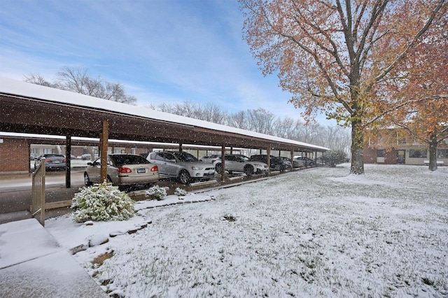 snow covered parking area featuring a carport