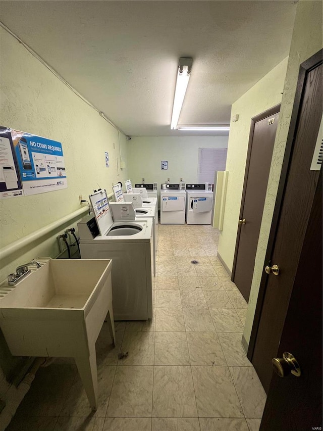 washroom with a textured ceiling and washing machine and dryer