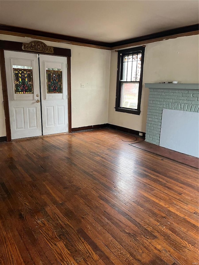 unfurnished living room featuring crown molding and wood-type flooring