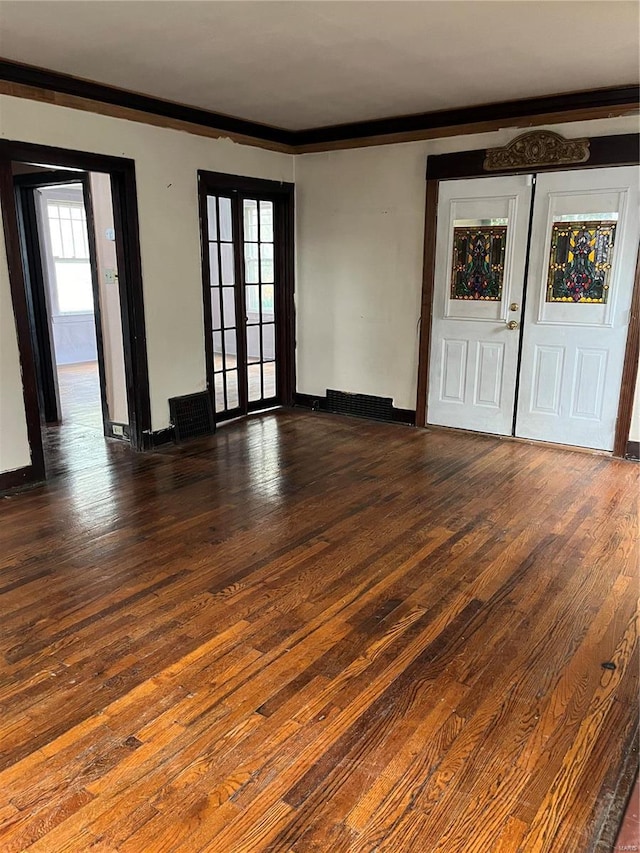 unfurnished room featuring dark hardwood / wood-style flooring, crown molding, and french doors