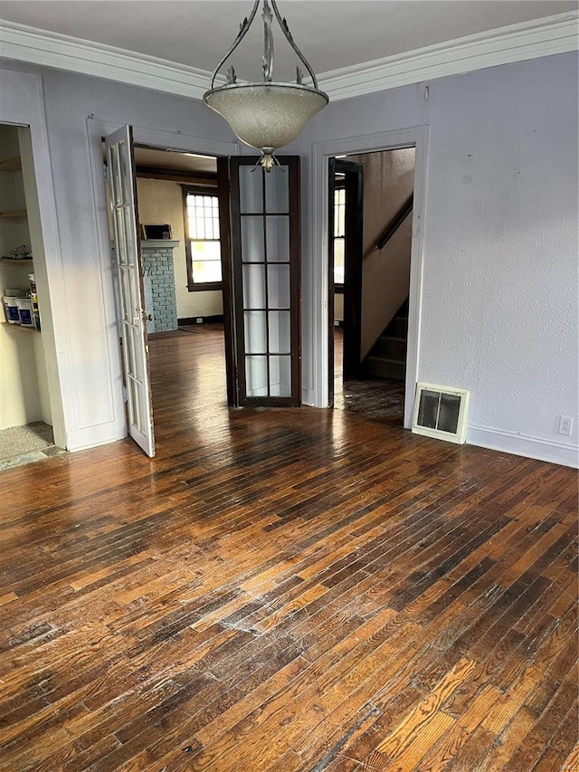 unfurnished dining area featuring ornamental molding and dark wood-type flooring