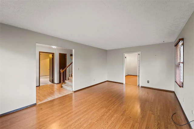 spare room with light hardwood / wood-style floors and a textured ceiling