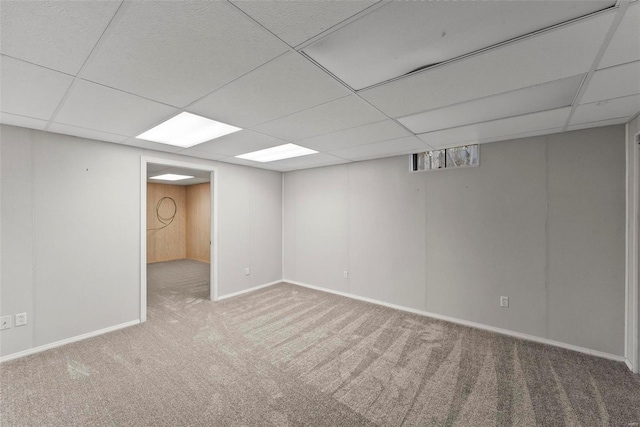 basement featuring a paneled ceiling and carpet floors