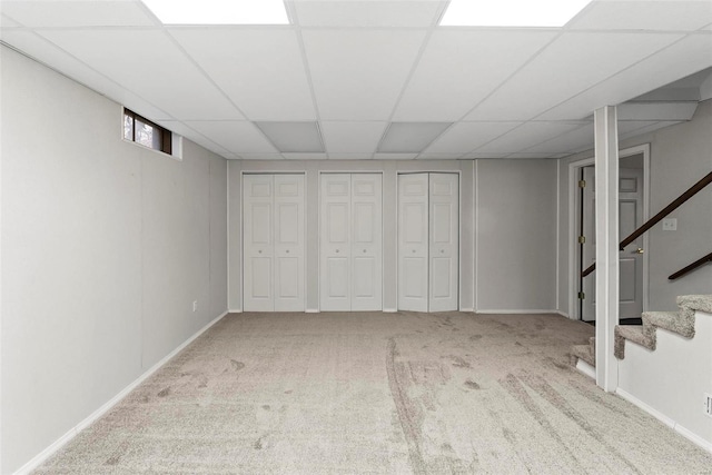 basement with light colored carpet and a drop ceiling