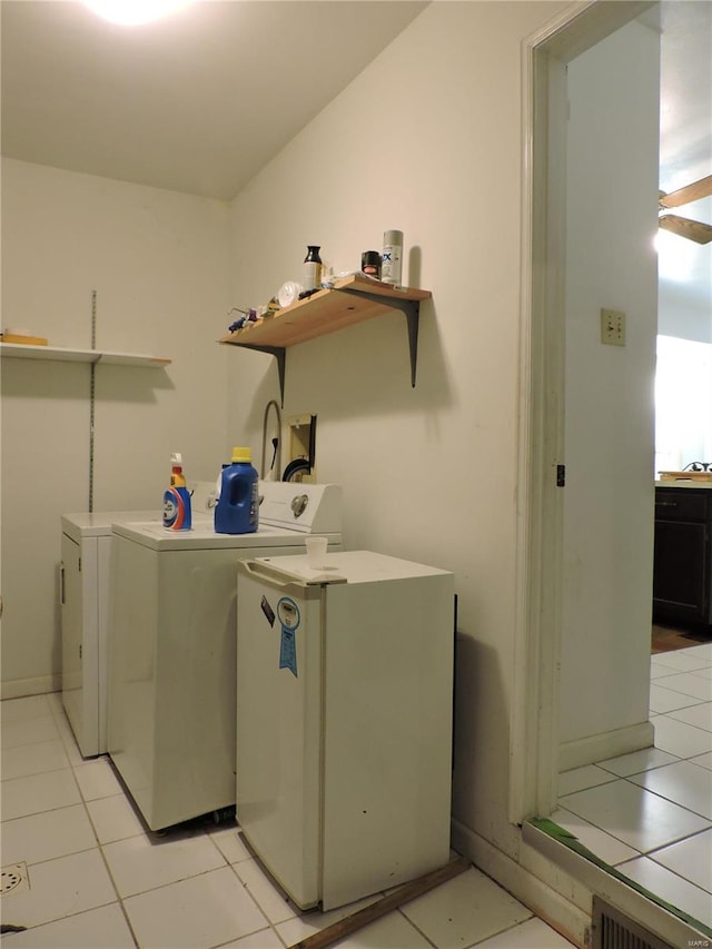 clothes washing area featuring washer and dryer and light tile patterned floors