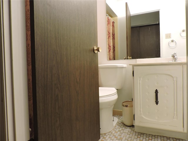 bathroom featuring tile patterned floors, vanity, and toilet