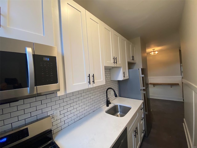 kitchen featuring decorative backsplash, stainless steel appliances, white cabinetry, and sink