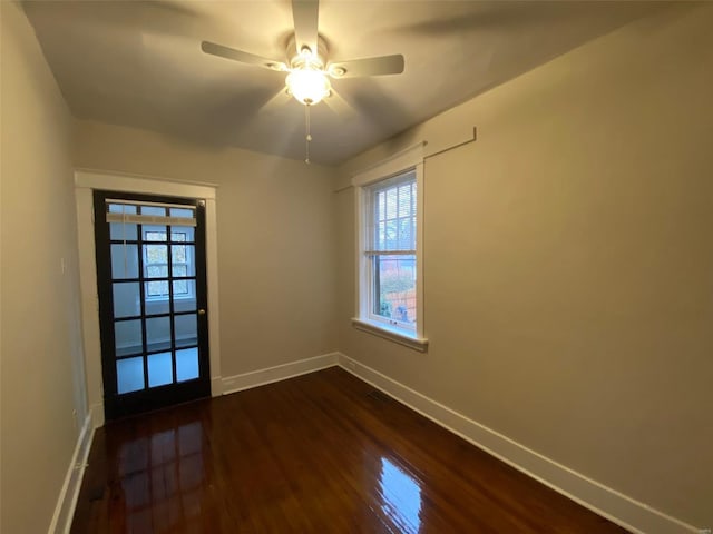 empty room featuring ceiling fan and dark wood-type flooring