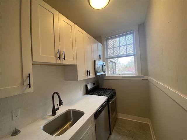 kitchen with white cabinets, backsplash, sink, and appliances with stainless steel finishes