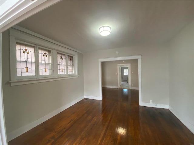 unfurnished room with dark hardwood / wood-style flooring