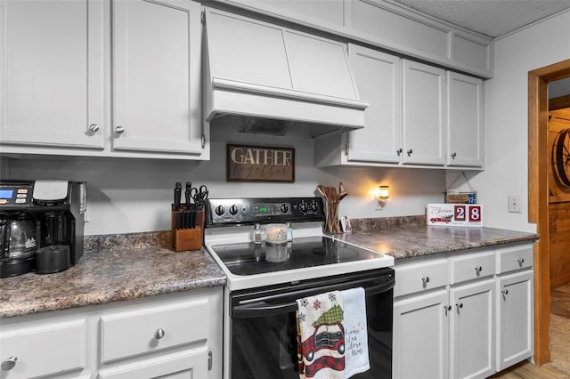 kitchen featuring light wood-type flooring, custom range hood, electric range, and white cabinetry