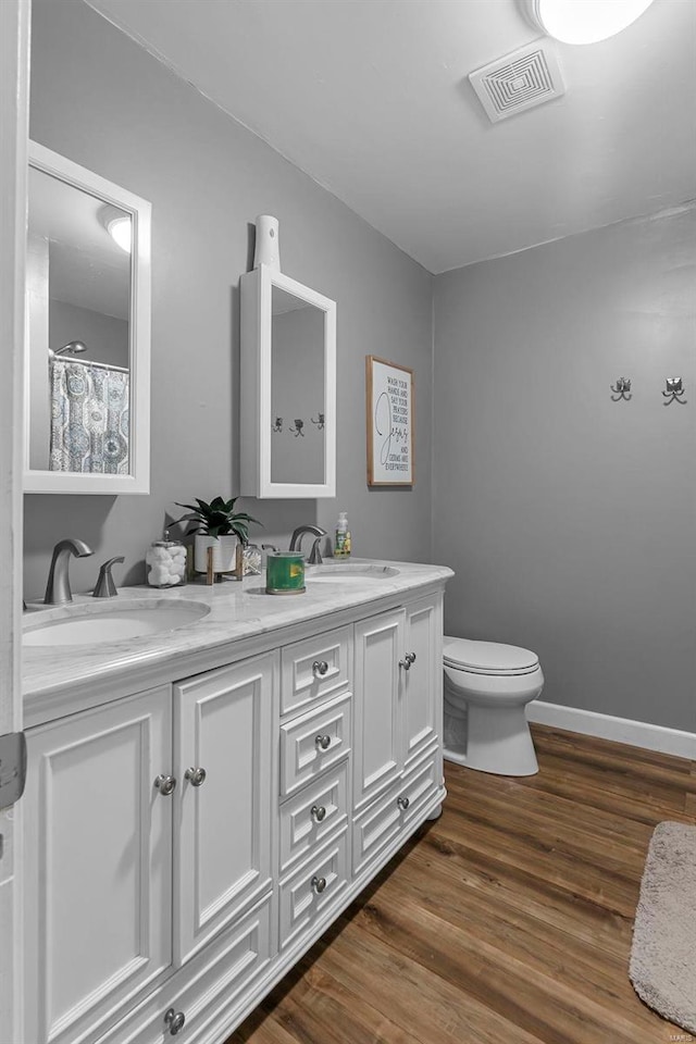 bathroom featuring hardwood / wood-style flooring, vanity, and toilet