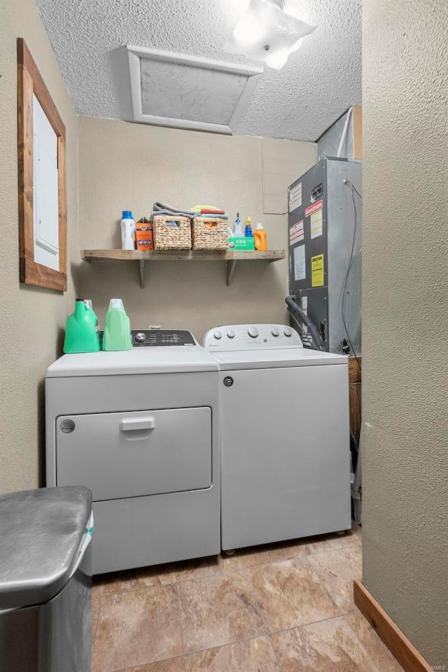 washroom featuring washer and dryer, a textured ceiling, and heating unit