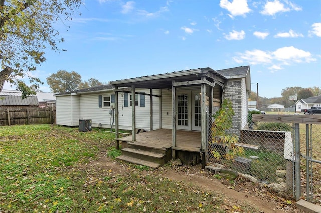 rear view of house featuring central AC unit and a deck