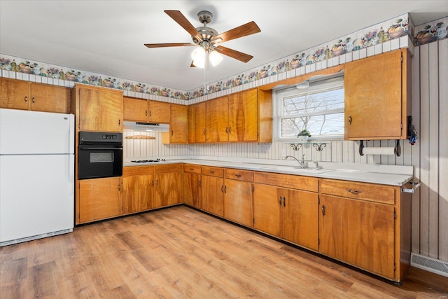 kitchen with sink, white appliances, ceiling fan, and light wood-type flooring