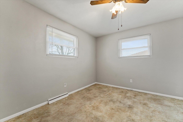 carpeted spare room with ceiling fan, a baseboard radiator, and a wealth of natural light