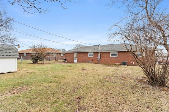 back of property featuring central AC unit and a lawn