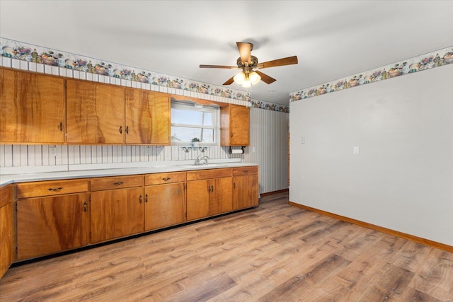 kitchen with sink, ceiling fan, and light hardwood / wood-style flooring