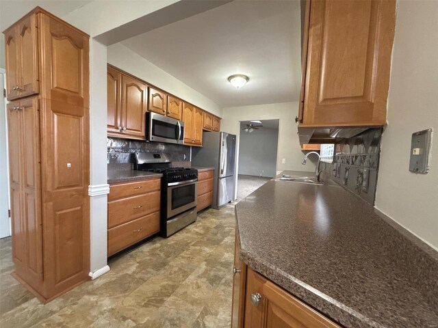 kitchen featuring tasteful backsplash, stainless steel appliances, ceiling fan, and sink