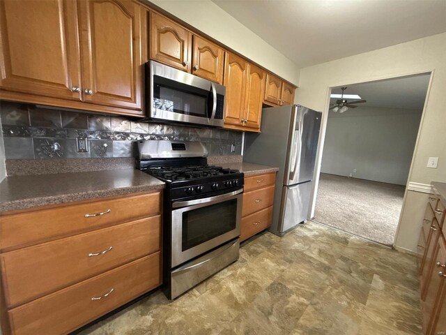 kitchen featuring ceiling fan, stainless steel appliances, and tasteful backsplash