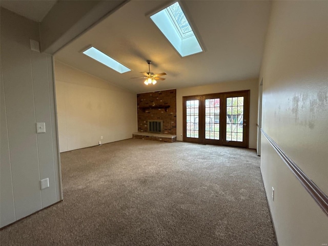 unfurnished living room with ceiling fan, carpet floors, lofted ceiling, and a brick fireplace