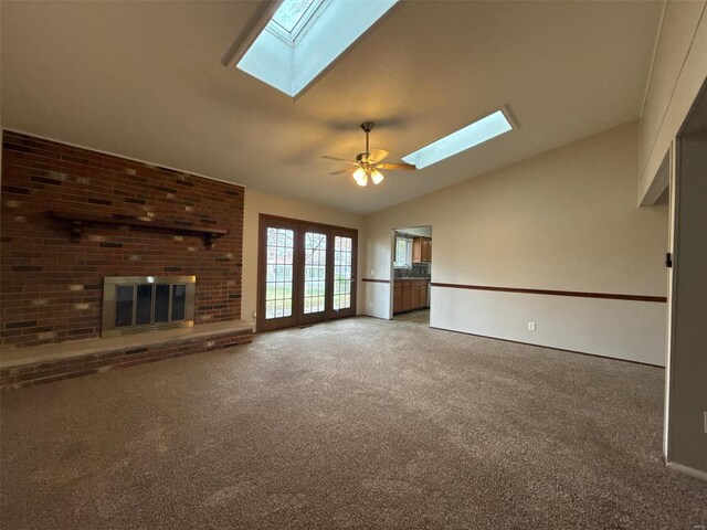 unfurnished living room with carpet flooring, a brick fireplace, ceiling fan, and lofted ceiling