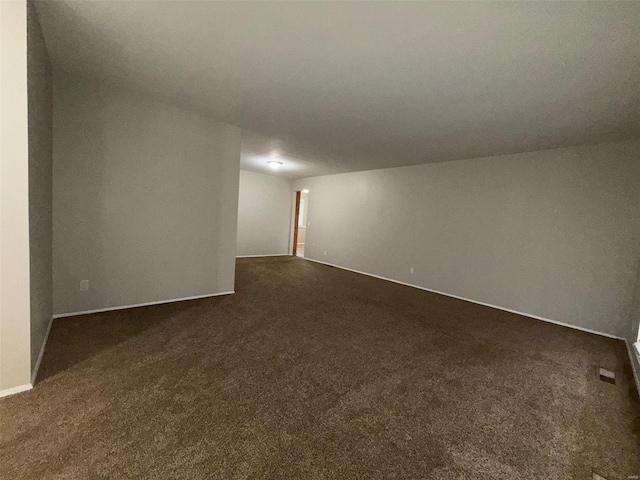 unfurnished room featuring dark carpet