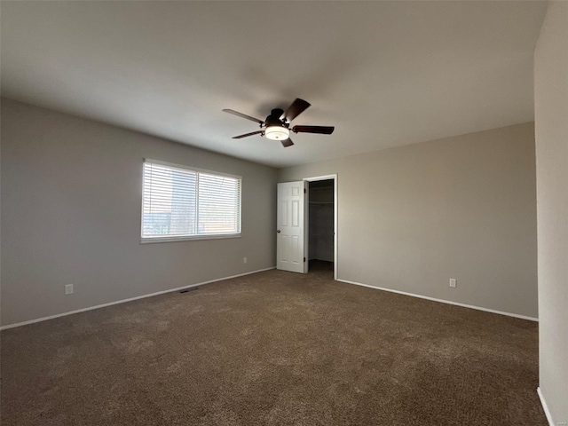 unfurnished bedroom with a closet, dark carpet, and ceiling fan