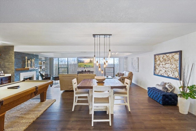 dining space with a fireplace, a textured ceiling, dark hardwood / wood-style flooring, and pool table