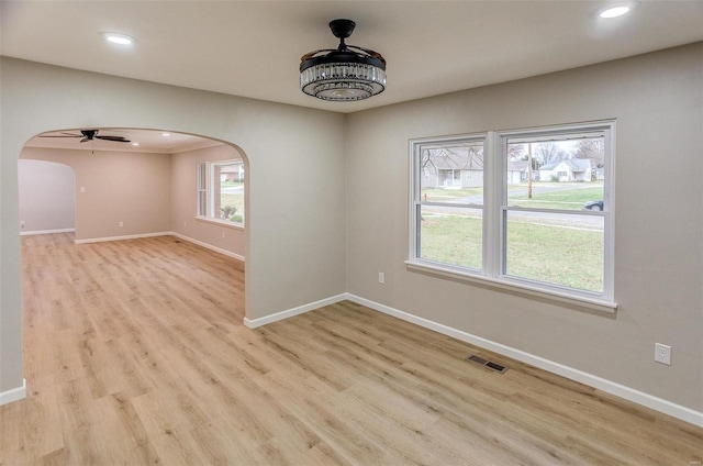 spare room featuring light hardwood / wood-style flooring, ceiling fan, and a healthy amount of sunlight