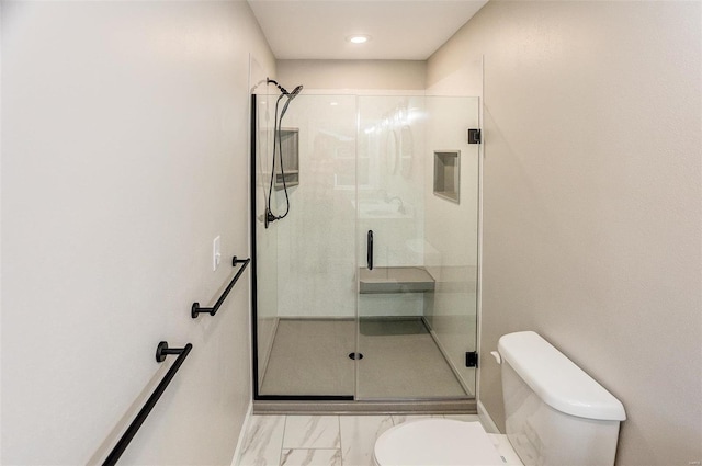 bathroom with a shower with shower door and toilet