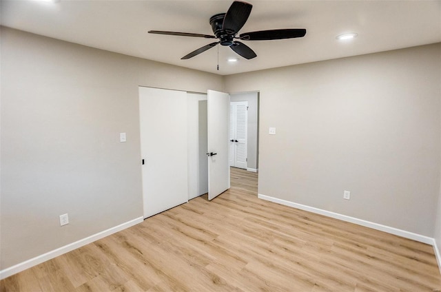 unfurnished bedroom with ceiling fan, a closet, and light wood-type flooring