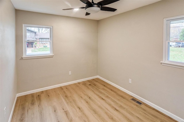 empty room with ceiling fan and light hardwood / wood-style flooring