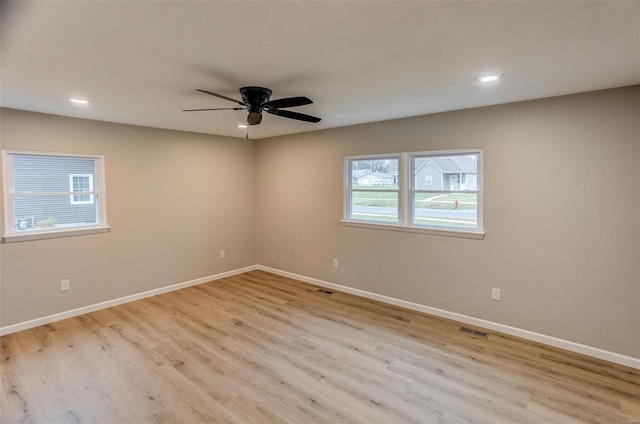 empty room with ceiling fan and light hardwood / wood-style flooring