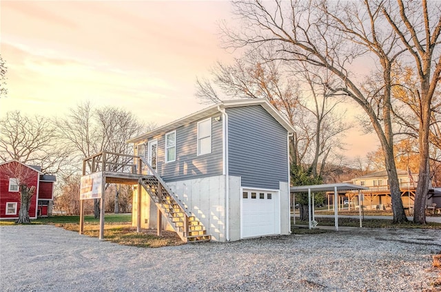 property exterior at dusk with a garage and a carport