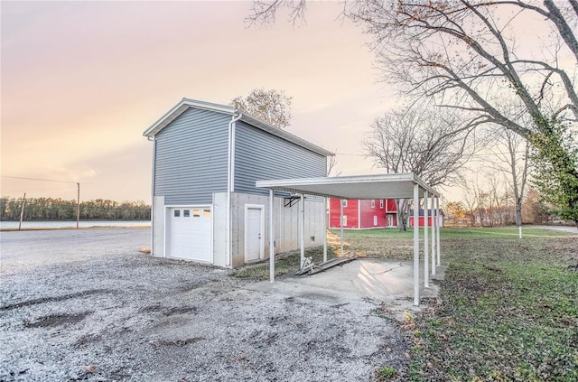 property exterior at dusk with a carport and a garage