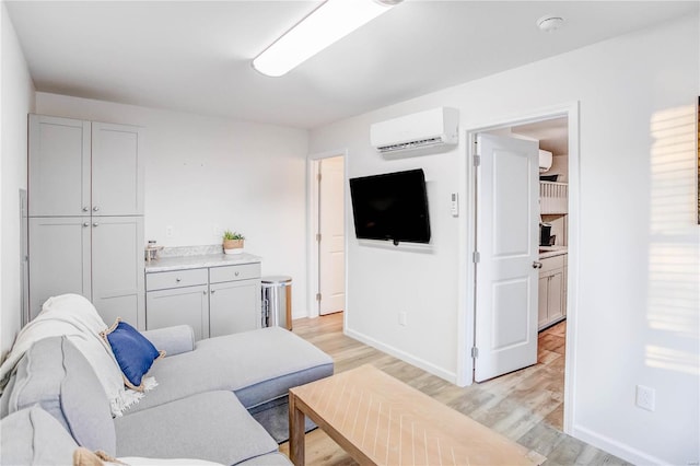 living room featuring light hardwood / wood-style flooring and a wall unit AC