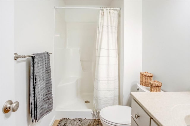 bathroom with toilet, vanity, and a shower with shower curtain