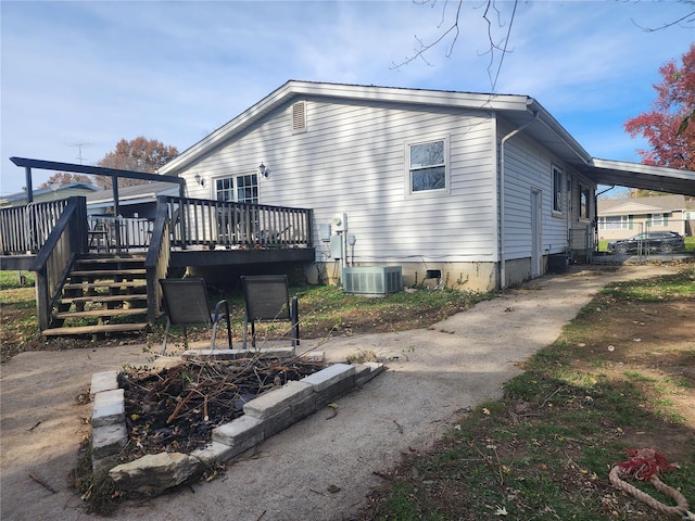 rear view of house with central air condition unit and a wooden deck