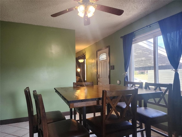 dining area featuring light tile patterned floors, a textured ceiling, and ceiling fan