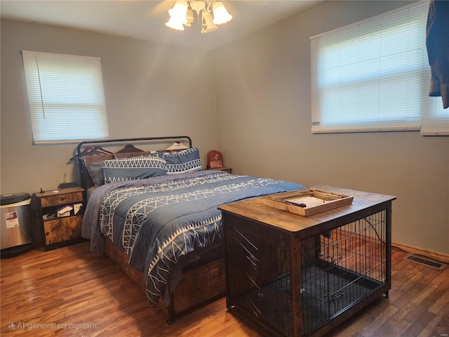 bedroom featuring wood-type flooring and a chandelier